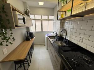 een kleine keuken met een spoelbak en een aanrecht bij Apartamento Gonzaga Conforto in Santos