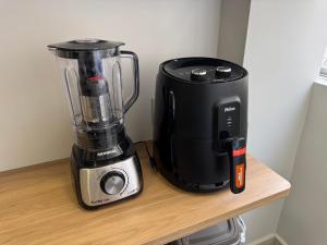 een blender die op een houten plank staat naast een blender bij Apartamento Gonzaga Conforto in Santos +5 foto's