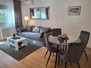 a living room with a table and a couch at Apartman TEO, self check-in, free parking in Slavonski Brod