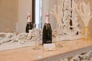 two bottles of wine sitting on a table with wine glasses at Butera 505-Luxury Suites in Bagheria