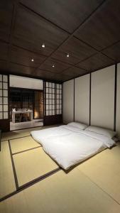 a bedroom with a large white bed in a room at Addostays - Mori Machiya in Bandung