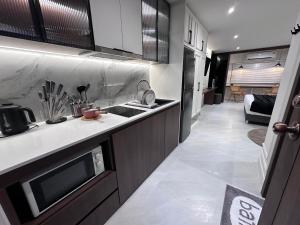 a kitchen with a sink and a microwave at Chill Chill at nimman Rm 402 in Chiang Mai