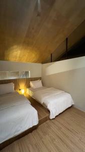 a bedroom with two beds and a ceiling at Addostays - Mori Machiya in Bandung +88 photos