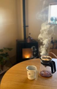 a coffee pot and a cup of coffee on a table at 白子の古民家bimbetta 星空の下で焚き火とバーベキュー in Shirako
