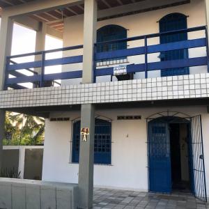 a building with blue doors and a balcony at Casa de Praia em Itamaracá in Vila Velha