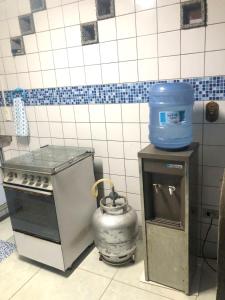 a kitchen with a stove and a jug on a counter at Casa de Praia em Itamaracá in Vila Velha