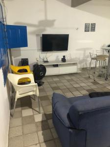 a living room with a tv and a couch and chairs at Casa de Praia em Itamaracá in Vila Velha