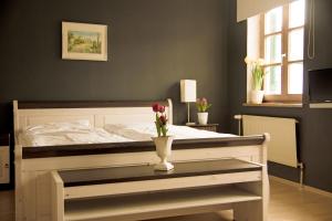 1 dormitorio con 1 cama con un jarrón de flores sobre una mesa en Gasthof Rabenwirt en Pullach im Isartal
