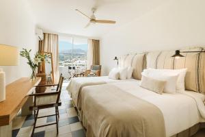 Una habitación de hotel con dos camas, un escritorio y una ventana. en Precise Resort Tenerife, en Puerto de la Cruz 37 fotos más