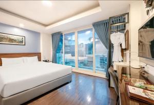 a bedroom with a bed and a large window at A25 Hotel - 46 Châu Long in Hanoi