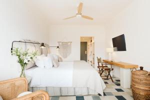 a white bedroom with a white bed and a desk at Precise Resort Tenerife in Puerto de la Cruz