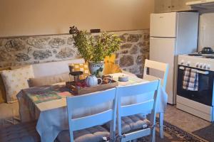 a kitchen with a table with chairs and a white refrigerator at Kallistws House in Zigovístion