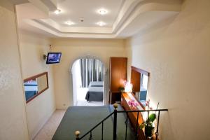 a room with a staircase and a hallway with a television at Hotel Delle Muse in Rome