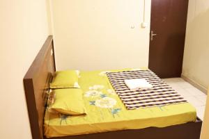 a bedroom with a bed with yellow sheets and flowers at TAJ Residency in Mannārakkāt