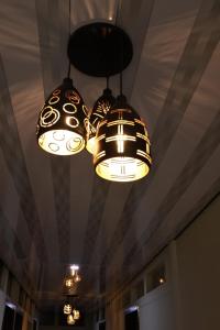 two lights hanging from a ceiling in a room at TAJ Residency in Mannārakkāt