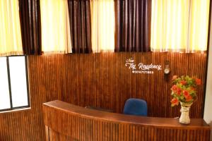 a desk with a vase of flowers in a room at TAJ Residency in Mannārakkāt