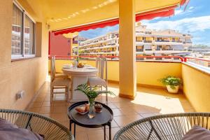 a balcony with a table and chairs and a building at Large Terrace Jardin Apartment in Puerto de Santiago