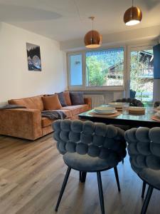 a living room with a couch and a table at Ferienwohnung mit Terrasse und Garten mit Blick auf das Karwendelgebirge in Mittenwald