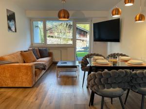 a living room with a couch and a table at Ferienwohnung mit Terrasse und Garten mit Blick auf das Karwendelgebirge in Mittenwald