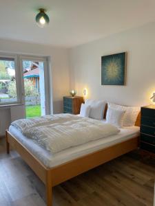 a bedroom with a large bed and a window at Ferienwohnung mit Terrasse und Garten mit Blick auf das Karwendelgebirge in Mittenwald