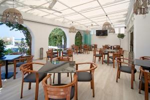 a restaurant with tables and chairs and a tv at Kyparissia Beach Hotel in Kyparissia