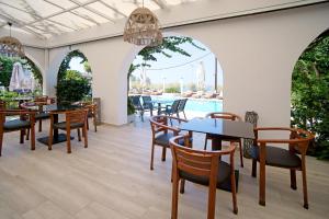 a restaurant with tables and chairs and a pool at Kyparissia Beach Hotel in Kyparissia +116 photos