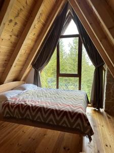 ジャブリャクにあるWonderwood Cabin 2の大きな窓のある部屋のベッド
