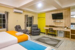 a hotel room with a bed and a desk and chairs at Sans Hotel City Park Medoho Semarang in Alastuwo