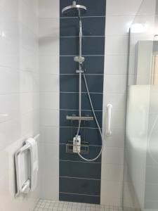 a bathroom with a urinal and a blue tile wall at Super studio coup de cœur in Niort +16 photos