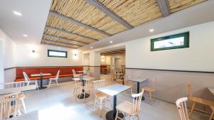 a restaurant with tables and chairs in a room at Erato Beach Hotel Adults Only by Smile Hotels in Platanias