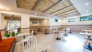 a restaurant with tables and chairs in a room at Erato Beach Hotel Adults Only by Smile Hotels in Platanias