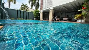 Una gran piscina azul con una fuente. en Ratana Hotel Rassada, PHUKET TOWN- SHA Extra Plus, en Phuket