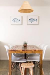 une table en bois avec des chaises et une plante en pot. dans l'établissement Casa Del Mar 6 - Walk to Pottsville Beach!, à Pottsville 11 autres photos
