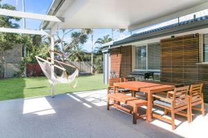 d'une terrasse avec un hamac, une table et des chaises. dans l'établissement Casa Del Mar 6 - Walk to Pottsville Beach!, à Pottsville