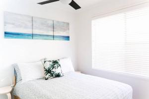 une chambre blanche avec un lit et une fenêtre dans l'établissement Casa Del Mar 6 - Walk to Pottsville Beach!, à Pottsville