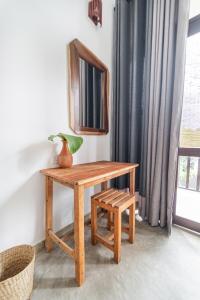 a wooden table with a mirror and a stool at Drifter - Rooms & Food in Midigama