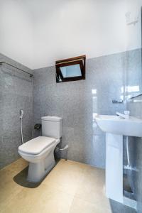 a bathroom with a toilet and a sink at Drifter - Rooms & Food in Midigama