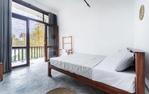 a bedroom with a bed and a large window at Drifter - Rooms & Food in Midigama