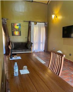 ein Wohnzimmer mit einem Holztisch und 2 Stühlen in der Unterkunft warujojo safari lodge in Malamagambo