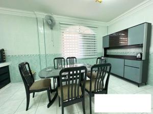 a dining room with a table and chairs in a kitchen at Ling's Homestay Miri in Miri
