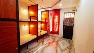 a room with two bunk beds and a mirror at Backpackers Station in Jammu