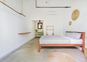 a bedroom with a bed in a white room at Drifter - Rooms & Food in Midigama