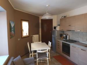 a kitchen with a table and a table and chairs at Appartamento Moia 34 in Albosaggia