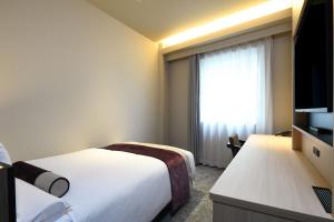 a hotel room with two beds and a television at HOTEL MYSTAYS Ochanomizu Conference Center in Tokyo