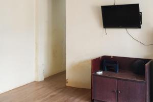 a room with a tv on a wall and a cabinet at RedDoorz at Ameria Bandara Nongsa Batam in Hang Nadim International Airport