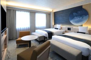 a hotel room with two beds and a tv at HOTEL MYSTAYS Ochanomizu Conference Center in Tokyo