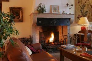 a living room with a couch and a fireplace at Hôtel Le Clos in Montagny-lès-Beaune