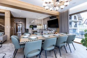 a kitchen and dining room with a large wooden table and chairs at Villa Lawendowy Prestige- balia, sauna, bilard in Czarna Góra