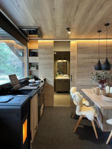 une cuisine avec une cuisinière et une table avec des chaises dans l'établissement refugio en el bosque, à La Molina