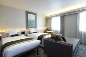 a hotel room with two beds and a couch at HOTEL MYSTAYS Ochanomizu Conference Center in Tokyo